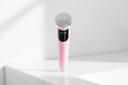 Pink electronic device with a silver top on a white background sitting onn a white table
